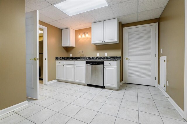 kitchen featuring white cabinets, dishwasher, light tile patterned floors, and sink