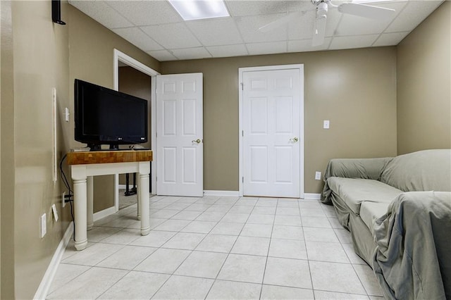 tiled living room featuring ceiling fan and a paneled ceiling