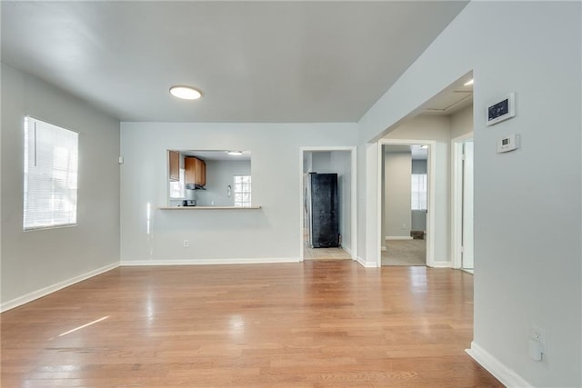 unfurnished living room featuring a healthy amount of sunlight and light hardwood / wood-style floors