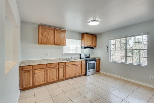 kitchen with sink, light tile patterned floors, and stainless steel gas range