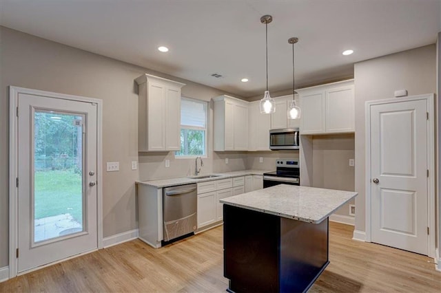 4230 Moore Rd, Conley, GA 30288 - kitchen with stainless steel appliances, white cabinets, light wood-style flooring, pendant lighting, and light stone countertops
