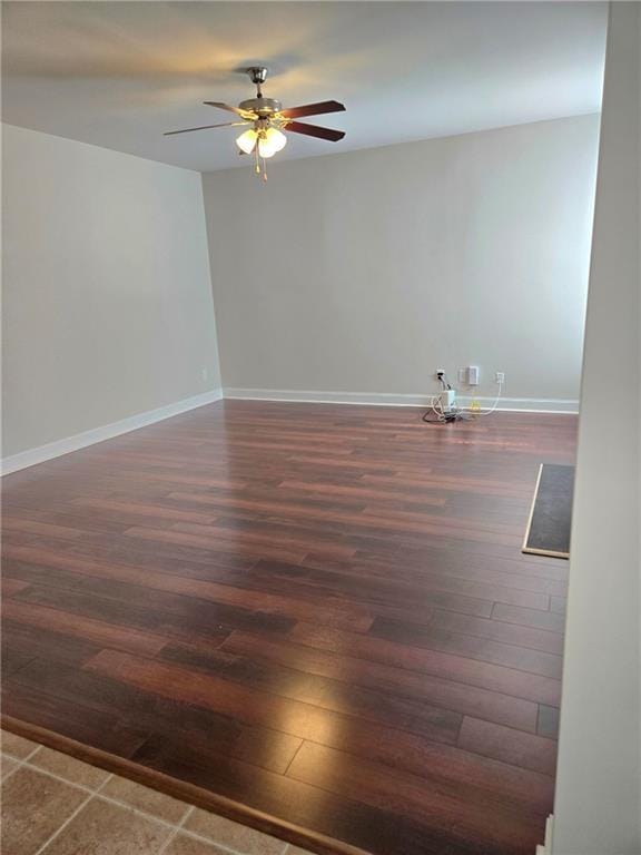 unfurnished room with dark wood-style floors, baseboards, and a ceiling fan