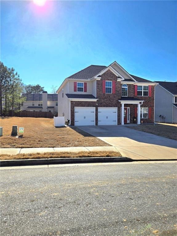 view of front of house featuring driveway, a garage, and brick siding