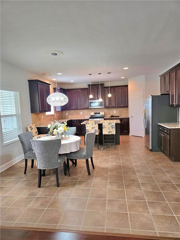 dining room featuring recessed lighting, baseboards, and light tile patterned floors