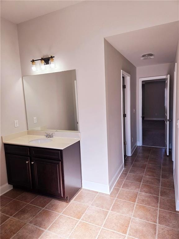 bathroom featuring vanity, baseboards, and tile patterned floors