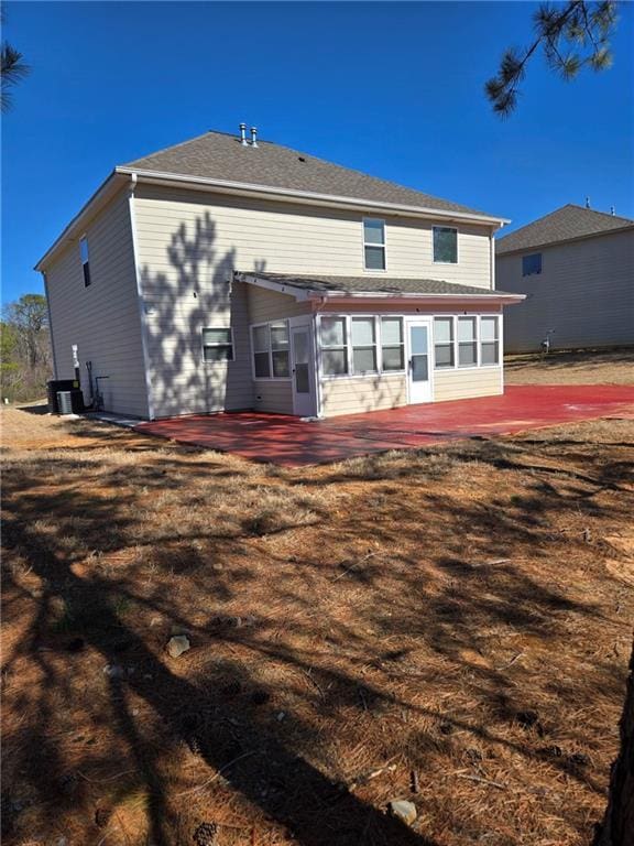 back of property featuring a patio, a yard, and a sunroom