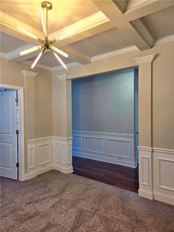 unfurnished room featuring ornamental molding, dark carpet, beam ceiling, and ornate columns