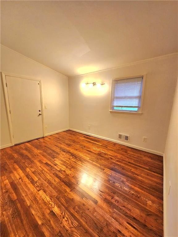 unfurnished room featuring lofted ceiling and hardwood / wood-style floors