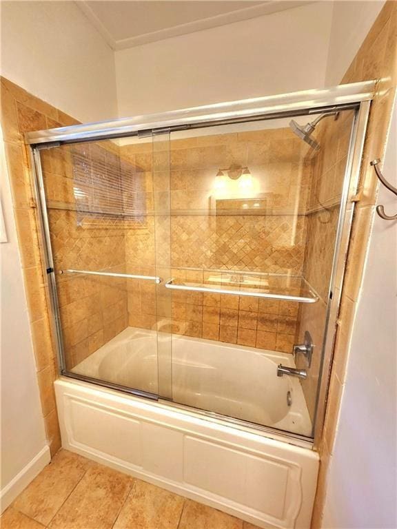 bathroom featuring tile patterned flooring and combined bath / shower with glass door