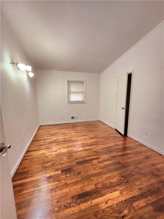 unfurnished room with wood-type flooring and vaulted ceiling