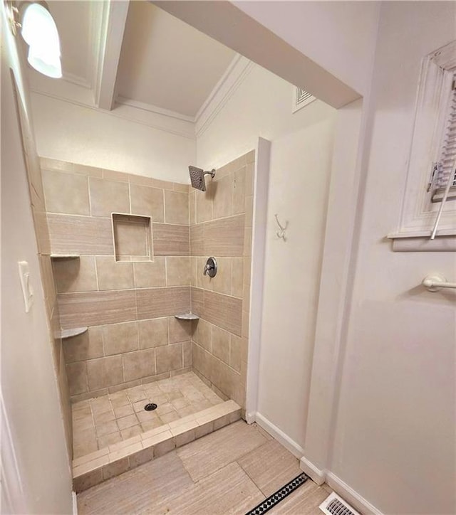 bathroom featuring ornamental molding and tiled shower