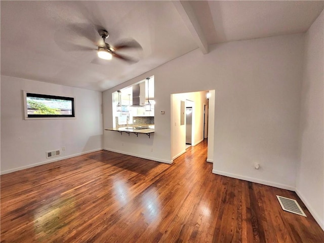 unfurnished living room featuring dark wood-type flooring, ceiling fan, and vaulted ceiling with beams