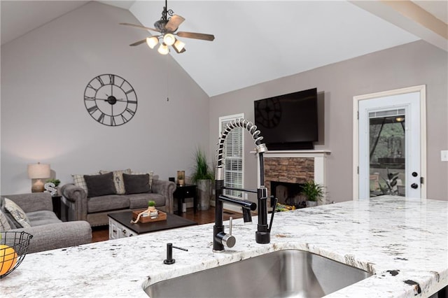 living room featuring a ceiling fan, high vaulted ceiling, and a fireplace