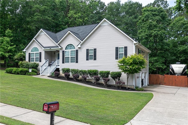view of front of house featuring driveway, an attached garage, and view of wooded area