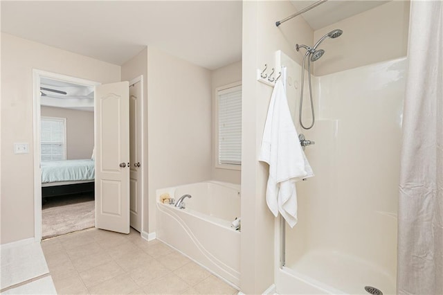 ensuite bathroom featuring a stall shower, a garden tub, and baseboards