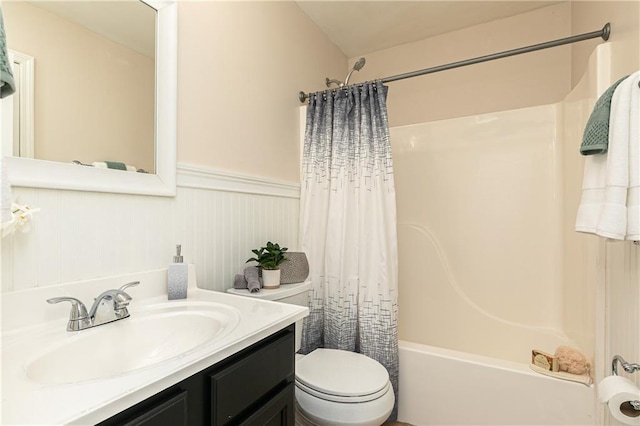 bathroom with wainscoting, toilet, vanity, and shower / bath combo