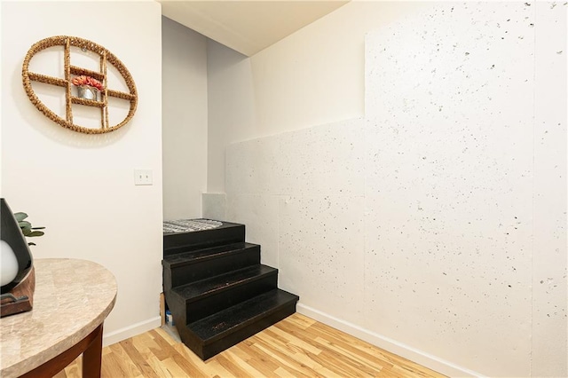 stairway featuring wood finished floors and baseboards