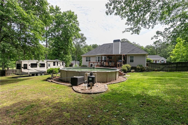 back of property with a chimney, a wooden deck, and view of scattered trees