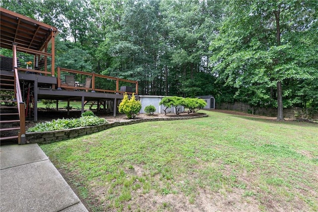 view of yard featuring stairway, a storage shed, a wooden deck, and an outdoor structure