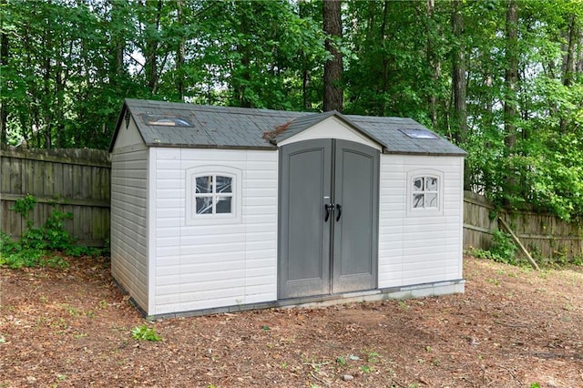 view of shed featuring fence and view of scattered trees