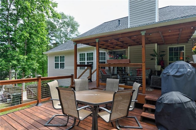 deck with outdoor dining area and a grill