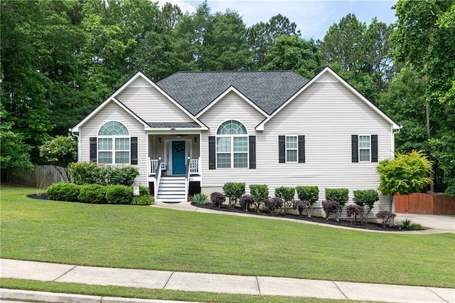 view of front of house with view of wooded area and roof with shingles