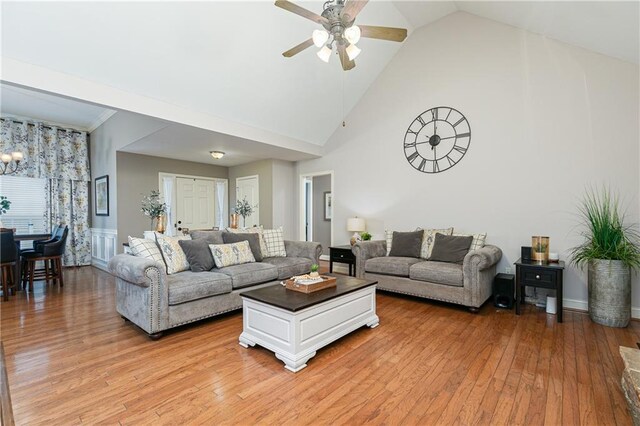 living area featuring a ceiling fan, light wood-style floors, and high vaulted ceiling