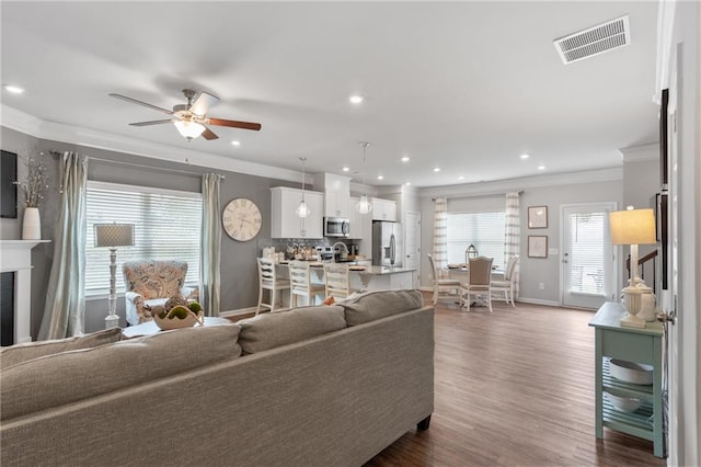 living room featuring dark wood-type flooring, ceiling fan, and crown molding