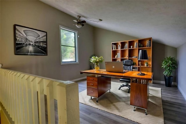 office space with baseboards, a ceiling fan, dark wood-style flooring, and lofted ceiling