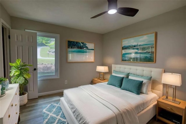 bedroom with a ceiling fan, wood finished floors, and baseboards