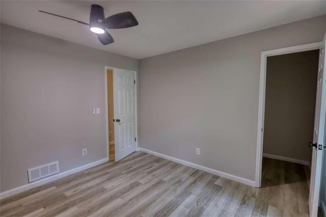 unfurnished room featuring visible vents, ceiling fan, wood finished floors, and baseboards