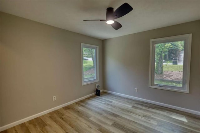 spare room featuring wood finished floors, a ceiling fan, and baseboards