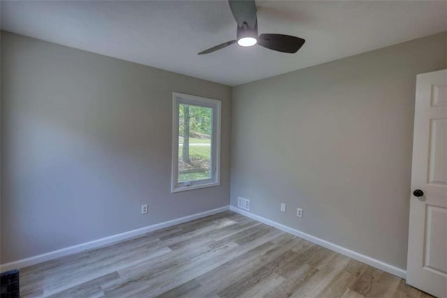 spare room with visible vents, ceiling fan, wood finished floors, and baseboards