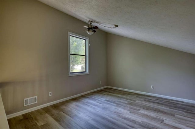 interior space featuring visible vents, wood finished floors, a ceiling fan, and a textured ceiling