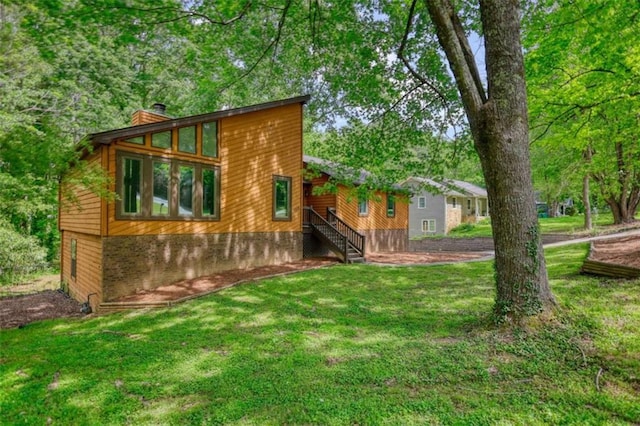 back of property with a lawn and a chimney