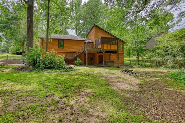 rear view of house featuring a wooden deck, a yard, and stairway