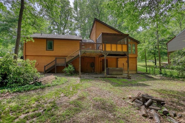 back of property featuring a wooden deck, stairs, and a hot tub