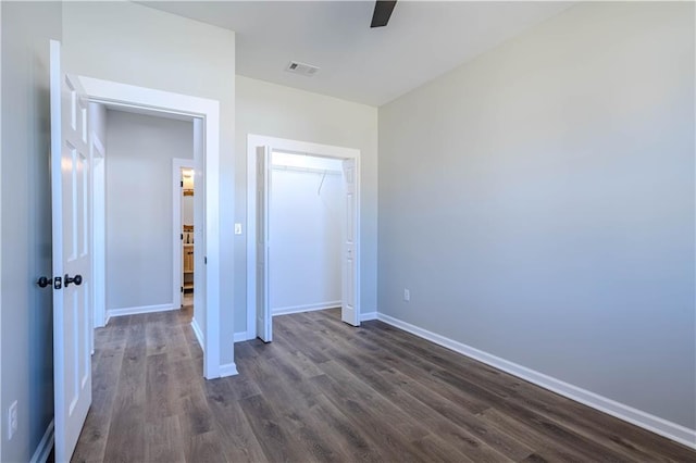 unfurnished bedroom with ceiling fan, dark hardwood / wood-style flooring, and a closet