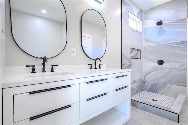 bathroom with vanity and a tile shower