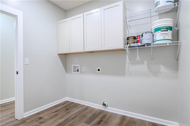 laundry room with electric dryer hookup, washer hookup, hardwood / wood-style floors, and cabinets