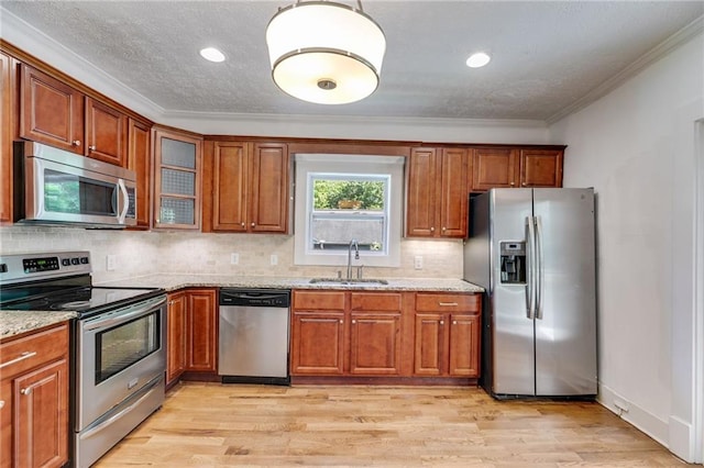 1405 May Ave SE, Atlanta, GA 30316 - kitchen featuring appliances with stainless steel finishes, a sink, crown molding, brown cabinetry, and light stone countertops