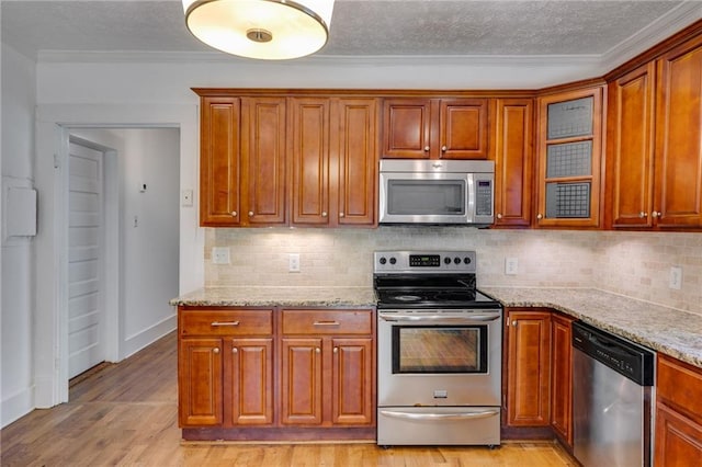 1405 May Ave SE, Atlanta, GA 30316 - kitchen with stainless steel appliances, a textured ceiling, light stone countertops, decorative backsplash, and crown molding