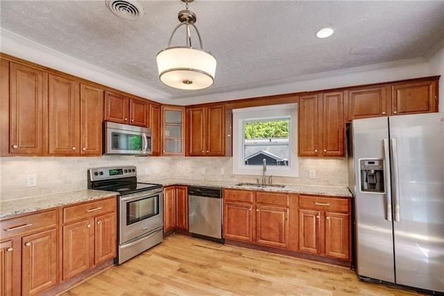 1405 May Ave SE, Atlanta, GA 30316 - kitchen featuring appliances with stainless steel finishes, a sink, brown cabinets, crown molding, and a textured ceiling