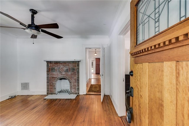 1405 May Ave SE, Atlanta, GA 30316 - unfurnished living room with ornamental molding, baseboards, a ceiling fan, wood-type flooring, and a brick fireplace