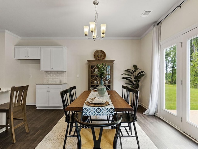 dining space with a notable chandelier, dark hardwood / wood-style floors, and crown molding