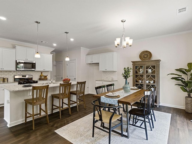 dining area featuring crown molding, a chandelier, and dark hardwood / wood-style floors