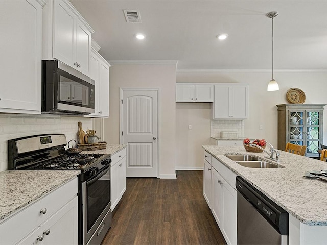 kitchen featuring appliances with stainless steel finishes, ornamental molding, a kitchen island with sink, pendant lighting, and white cabinetry