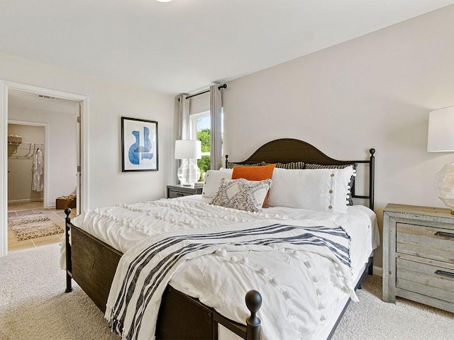 carpeted bedroom with a walk in closet