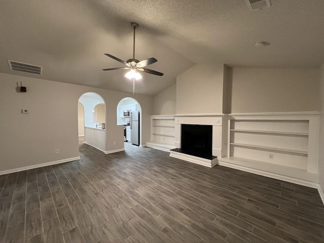 unfurnished living room with dark hardwood / wood-style flooring, a textured ceiling, lofted ceiling, and ceiling fan