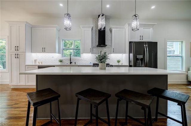 115 Dahlia Ave NW, Atlanta, GA 30314 - kitchen with black fridge with ice dispenser, a center island, white cabinets, backsplash, and light countertops